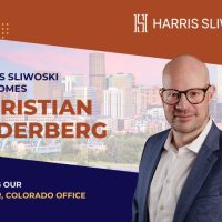 A man in a suit and glasses stands in front of a cityscape with text welcoming Christian Sederberg to Harris Sliwoski’s Denver, Colorado office.
